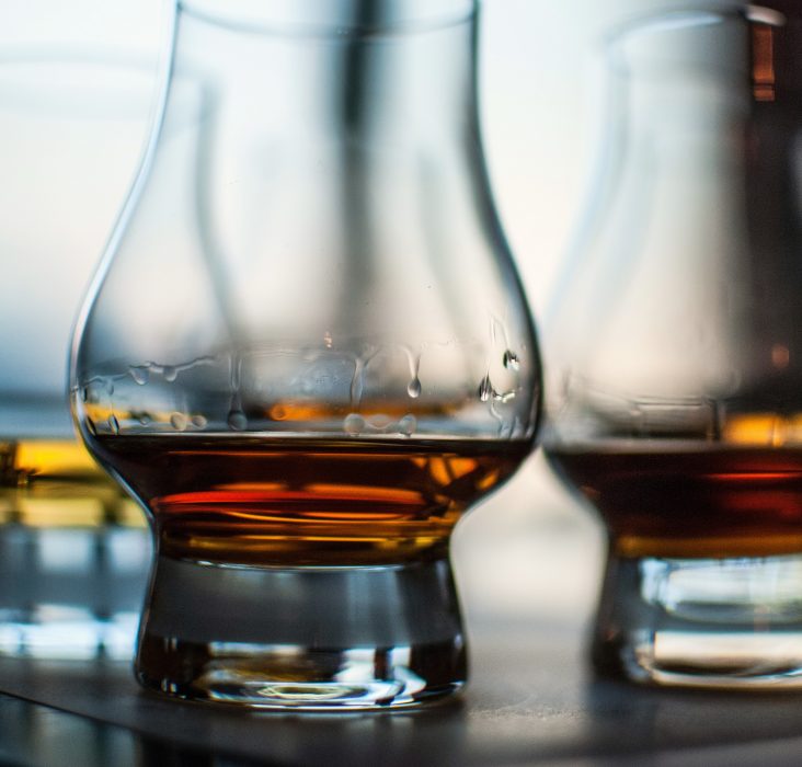 A closeup shot of three glasses of whiskey on blurred background
